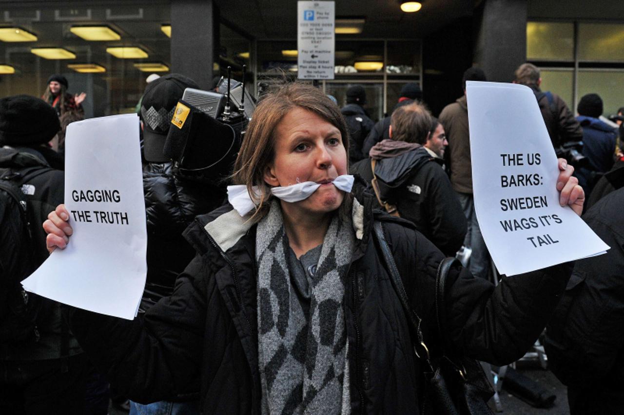 \'A gagged demonstrator holds placards during a protest over the arrest of the WikiLeaks founder, Julian Assange, outside the City of Westminster Magistrates\' Court in central London, on December 7, 