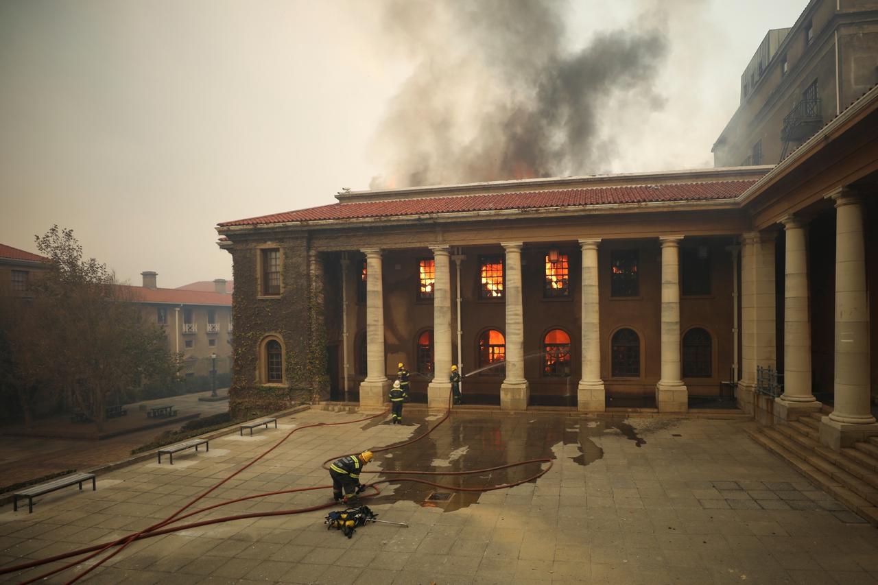 Firefighters battle flames as the library at the University of Cape Town burns, in Cape Town