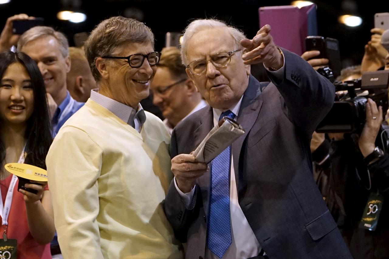 Berkshire Hathaway CEO Warren Buffett (R) shows his friend Microsoft co-founder Bill Gates the finer points of newspaper tossing, prior to the Berkshire annual meeting in Omaha, Nebraska May 2, 2015.  REUTERS/Rick Wilking