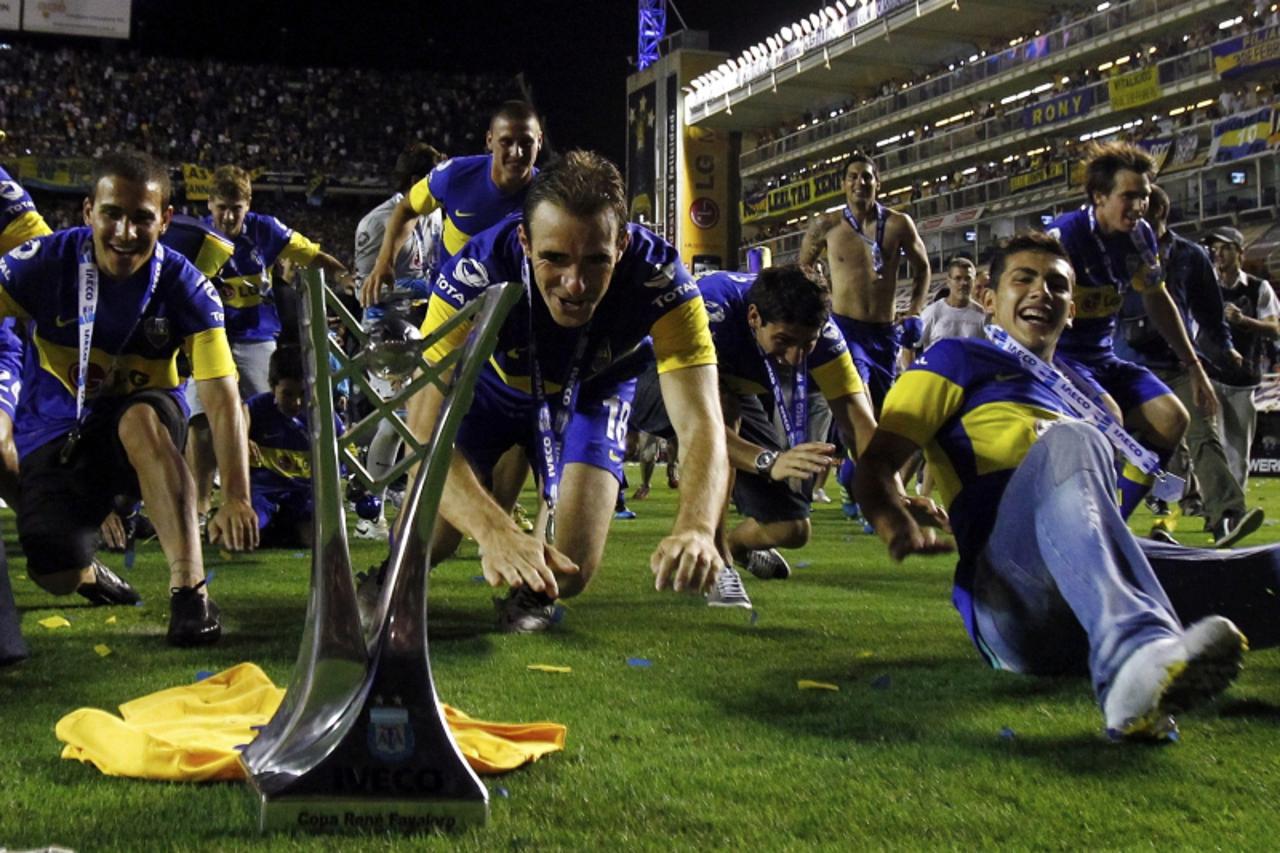 'Boca Juniors\' Leandro Somoza (C) and teammates celebrate with the trophy at the end of their Argentine First Division soccer match against Banfield in Buenos Aires, December 4, 2011. Boca Juniors wo