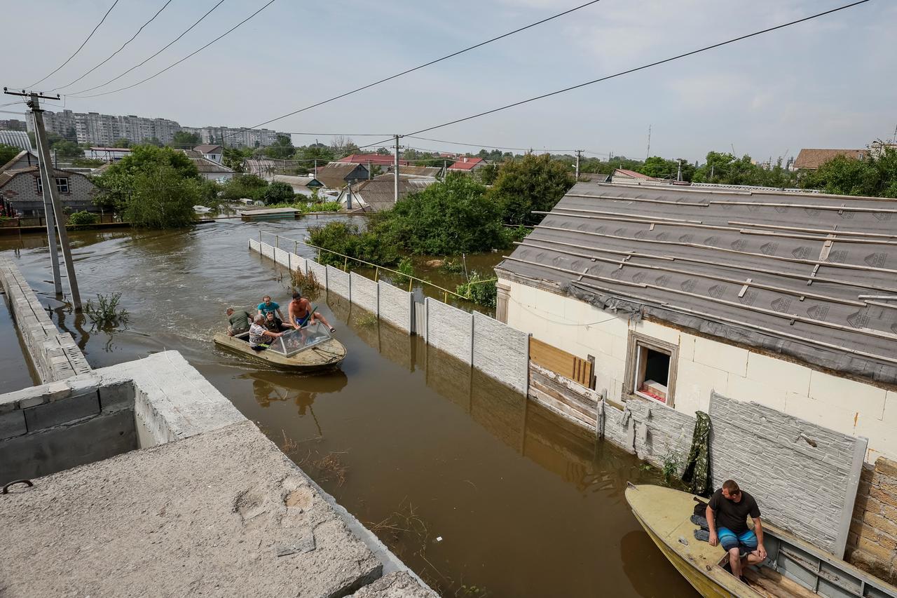 Local residents evacuate personal belongings and pets from a flooded area after the Nova Kakhovka dam breached, in Kherson