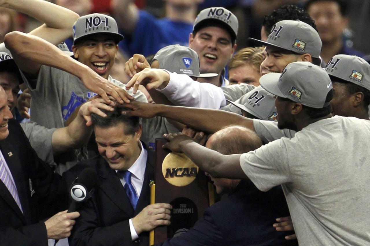 'Kentucky Wildcats forward Anthony Davis (L) and other players mess up the hair of head coach John Calipari as he holds the championship trophy after the Wildcats defeated the Kansas Jayhawks in the m
