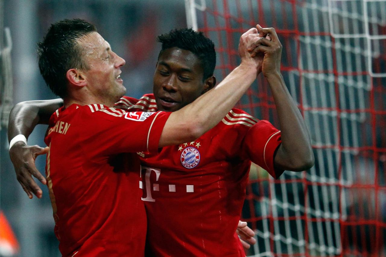 'FC Bayern Munich\'s Ivica Olic and David Alaba (R) celebrate during their German Bundesliga first division soccer match against Wolfsburg in Munich, January 28, 2012.            REUTERS/Michael Dalde