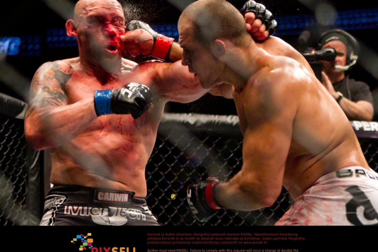 'Junior Dos Santos, right, of Brazil, hits Shane Carwin, of Greeley, Colo., during their main event heavyweight mixed martial arts bout at UFC 131, Saturday, June 11, 2011, in Vancouver, British Colum