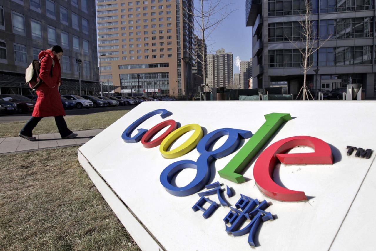 'A woman walks past the logo of Google in front of its headquarters in Beijing in this January 12, 2011 file photo. Hackers likely based in China tried to break into hundreds of Google mail accounts, 
