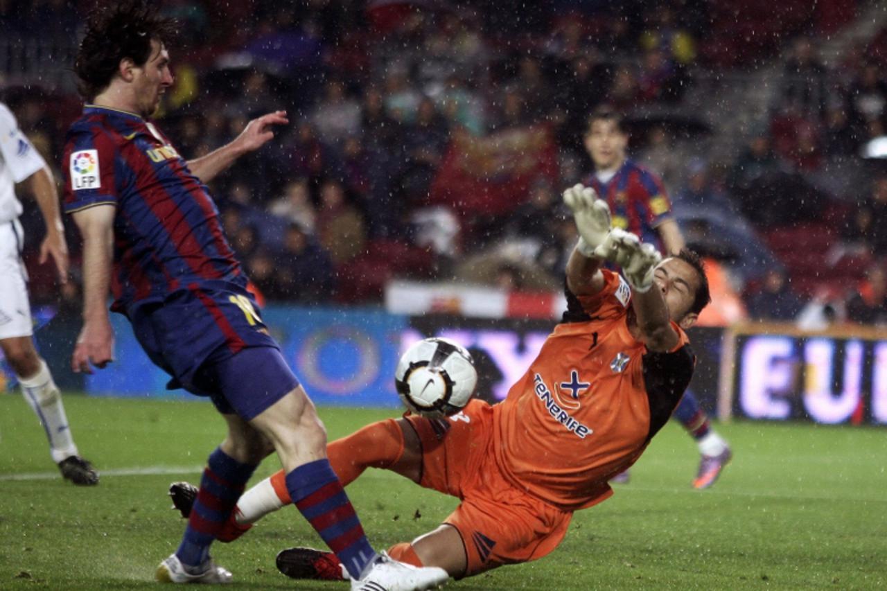 'Barcelona\'s Lionel Messi (L) scores his goal over Tenerife\'s goalkeeper Sergio Aragoneses during their Spanish first division soccer match at Nou Camp stadium in Barcelona May 4, 2010.      REUTERS