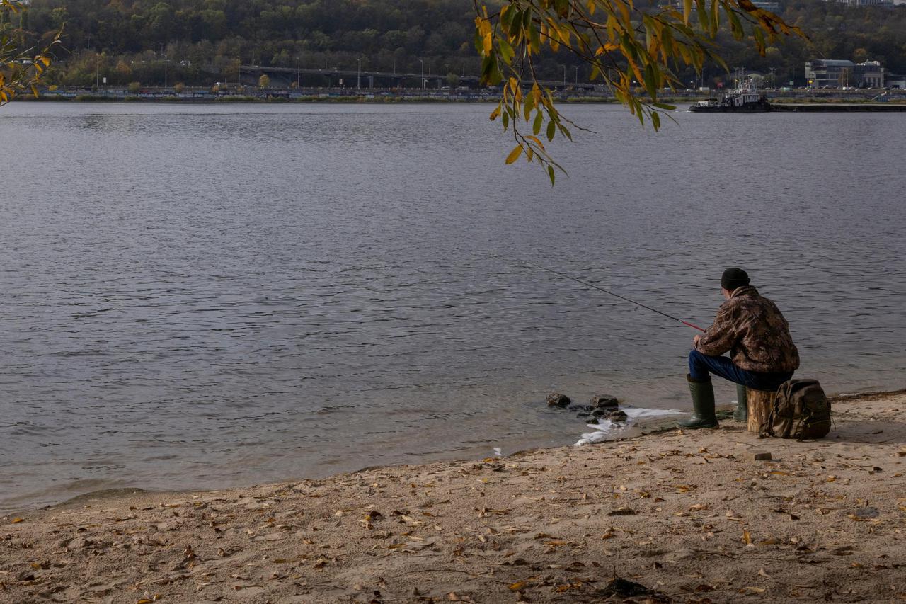 A man fishes in the Dnipro river in Kyiv