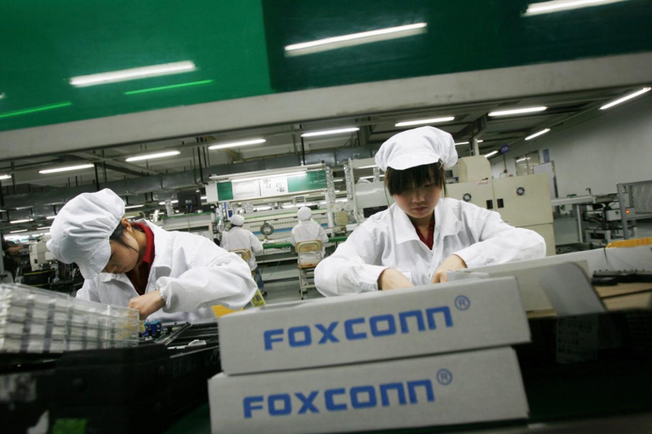 'Workers are seen inside a Foxconn factory in the township of Longhua in the southern Guangdong province in this May 26, 2010 file photo. A broad and bruising downturn is sweeping through China\'s gia