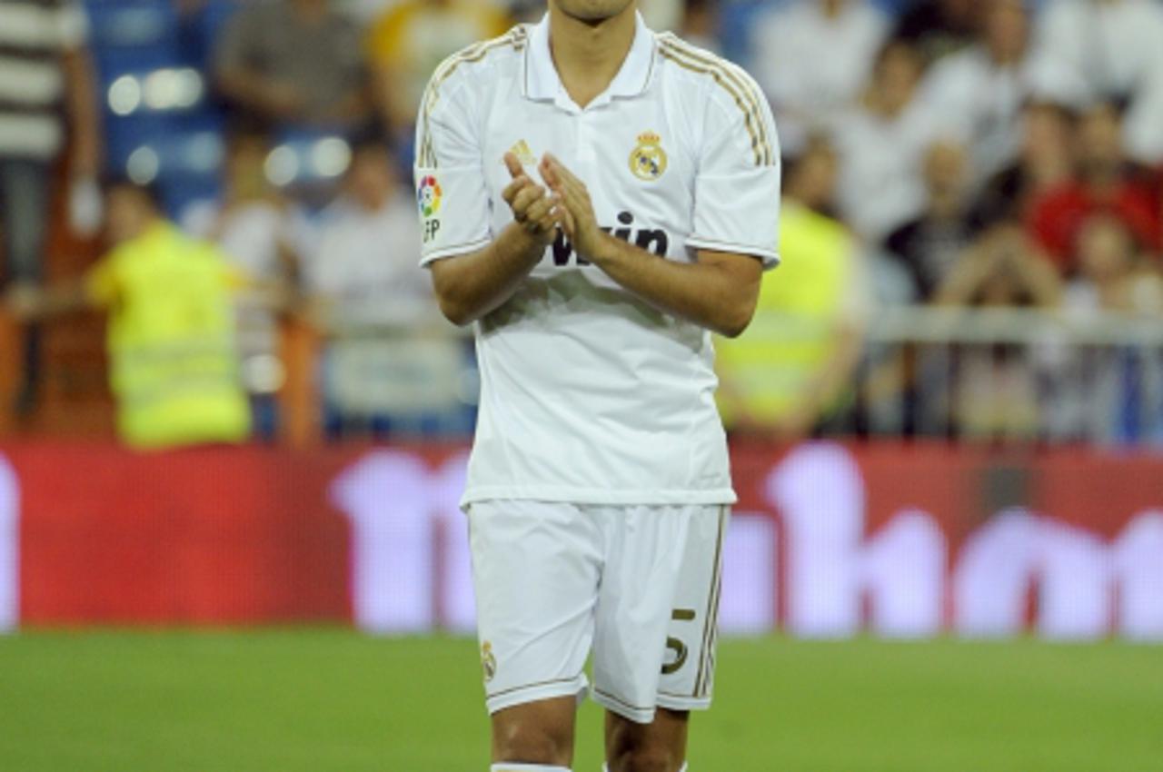 'Real Madrid\'s Nuri Sahin claps while standing in the line up before his team\'s Santiago Bernabeu trophy match against Galatasaray at the Santiago Bernabeu Stadium, on August 24, 2011 in Madrid. AFP