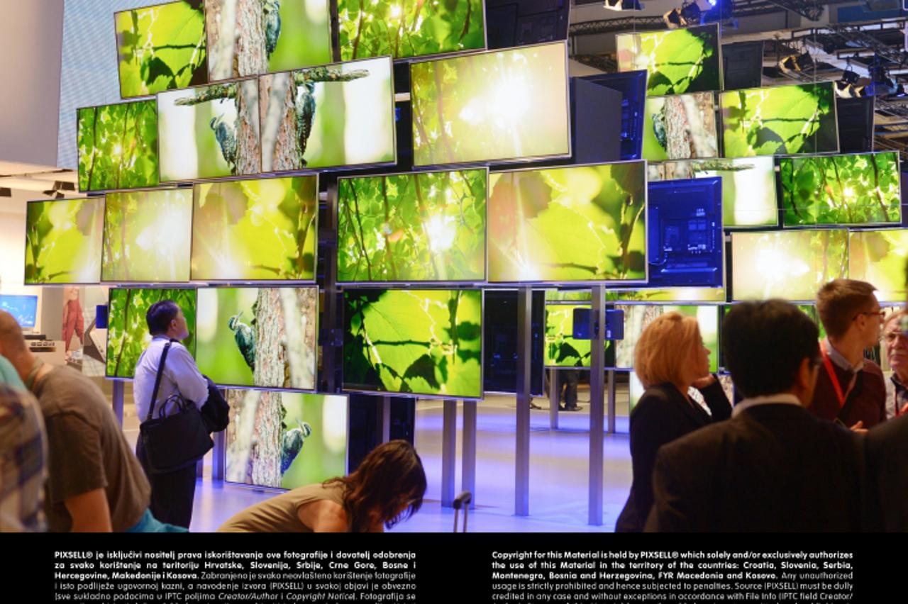 'Visitors stand in front of a wall of 4K televisions at the fair stand of electronics manufacturer Panasonic during the media day  at the International radio exhibition (IFA) in Berlin, Germany, 4 Sep