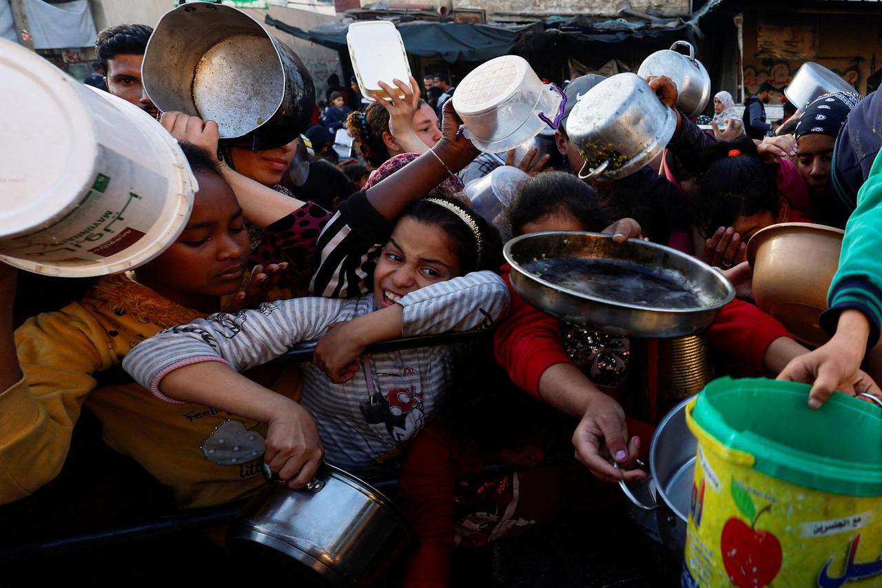 Palestinians wait ot receive food during Ramadan, in Rafah