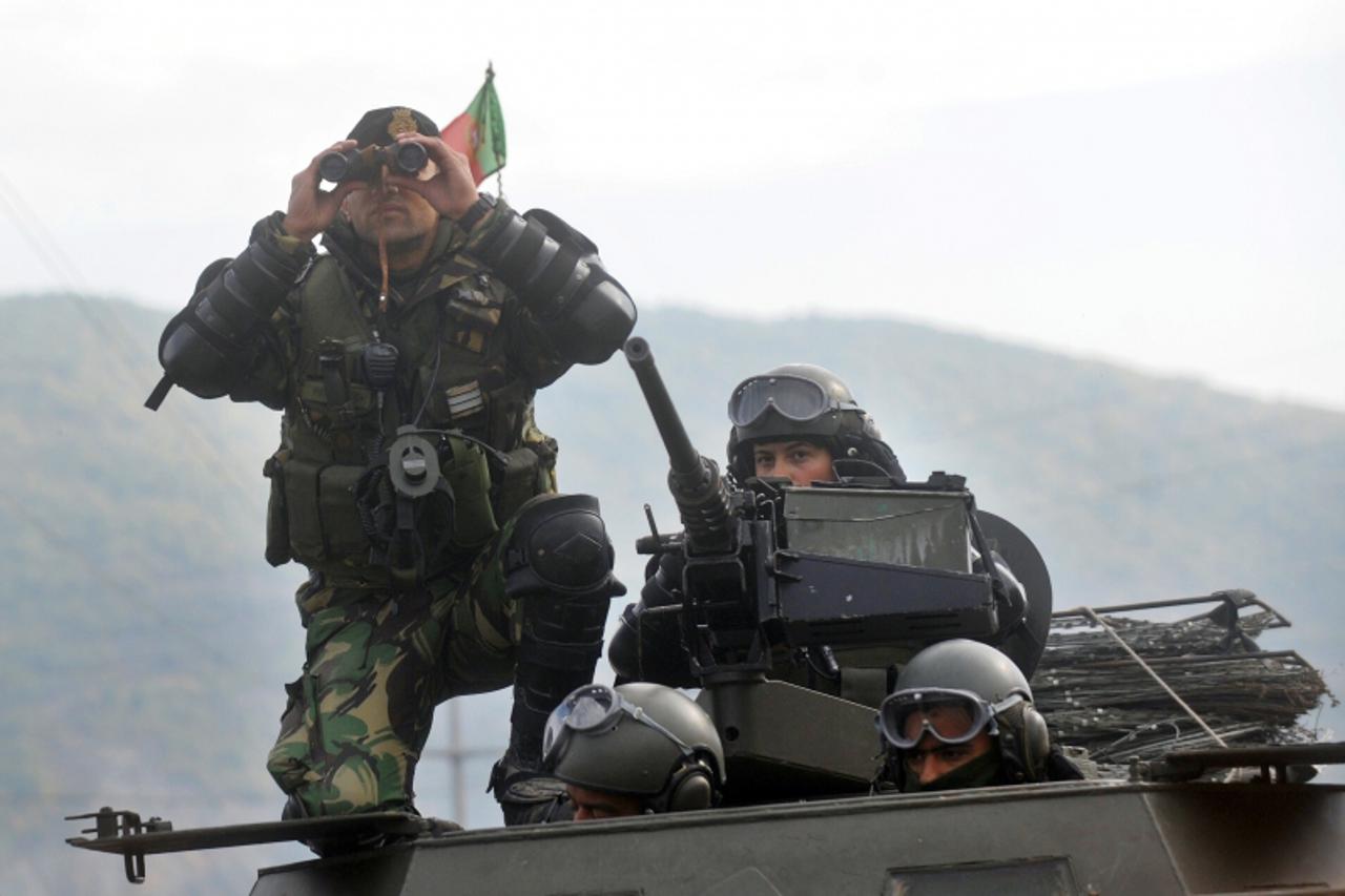 'Portuguese NATO-led peacekeepers (KFOR) stand guard at the entrance of the village of Zupce, in Serb-majority northern Kosovo, on October 21, 2011. NATO-led peacekeepers in Kosovo offered to meet wit