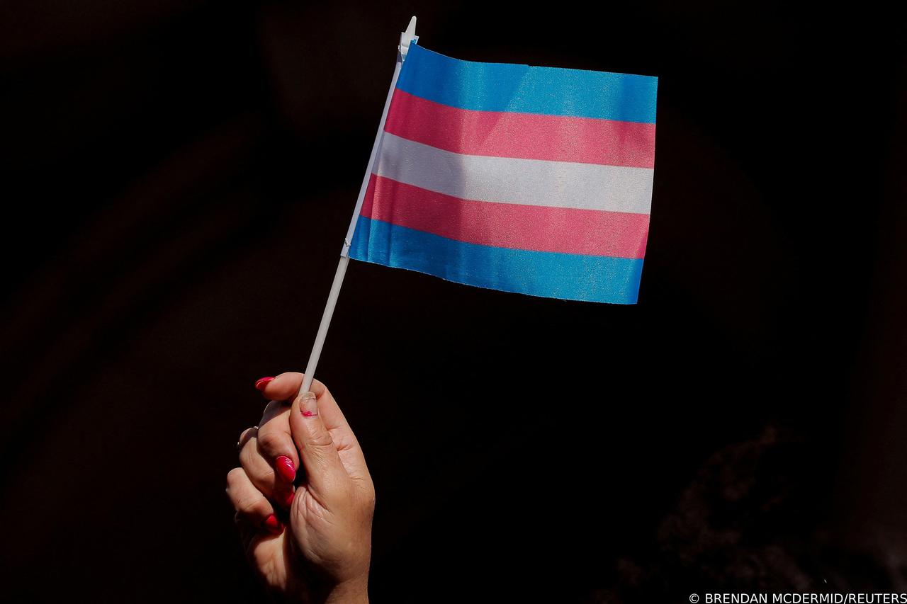 FILE PHOTO: A person holds up a flag during rally to protest the Trump administration's reported transgender proposal to narrow the definition of gender to male or female at birth in New York
