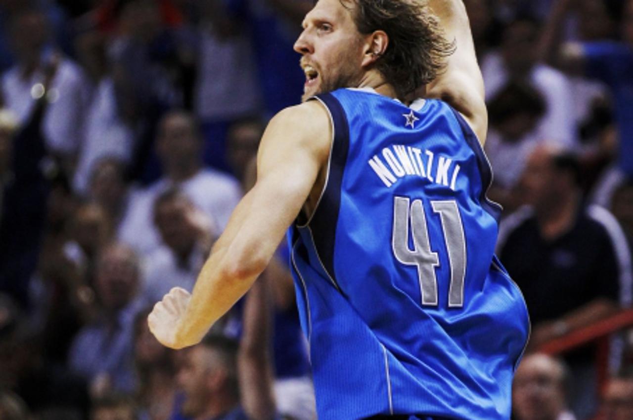 'Dallas Mavericks\' Dirk Nowitzki celebrates after making a basket against the Miami Heat  during the fourth quarter in Game 6 of the NBA Finals basketball series in Miami, June 12, 2011. REUTERS/Hans