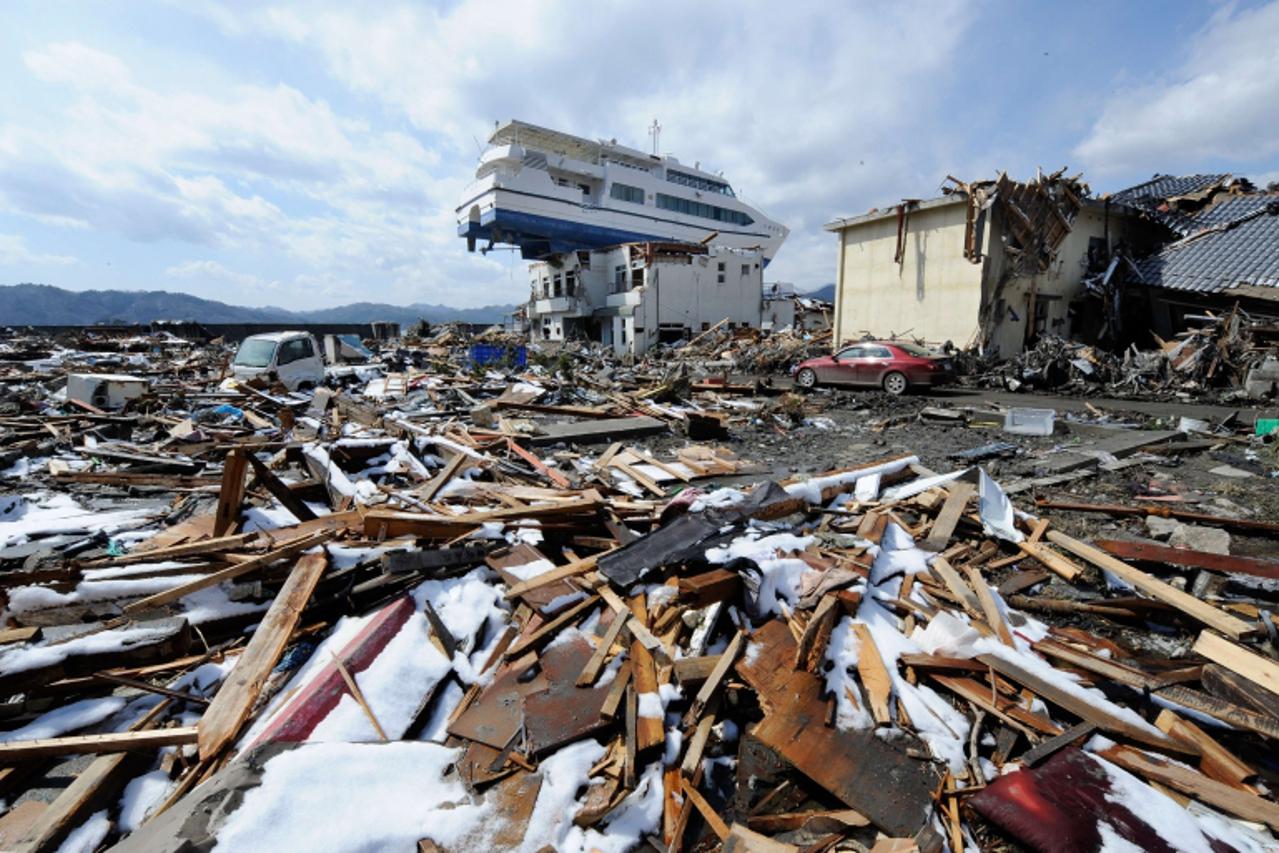 \'A cruise ship lies on the roof of a two storey building in Otsuchi, Iwate Prefecture, on March 24, 2011, after the recent earthquake and tsunami disaster.   Three workers at Japan\'s stricken Fukush