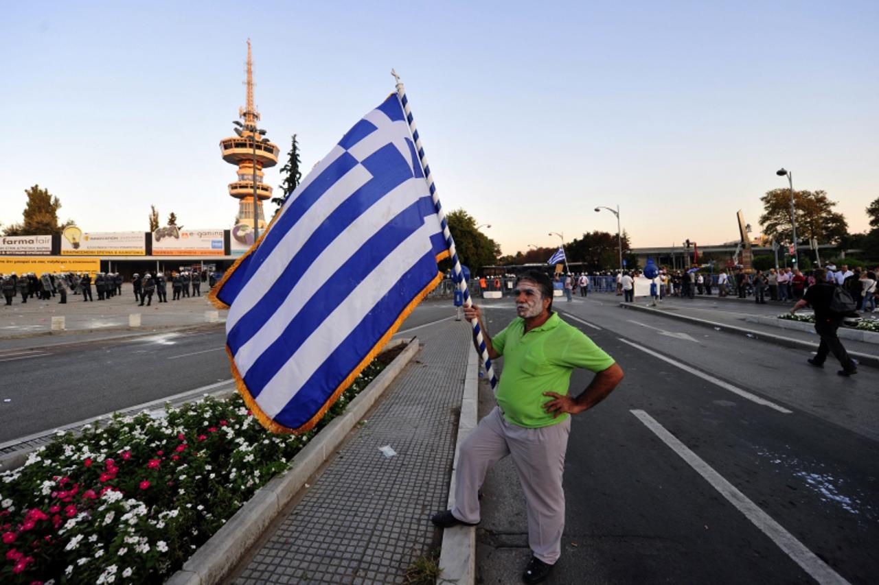 'A demonstrator holds a Greek flag during a protest in Thessaloniki, northern Greece on September 10, 2011. Clashes broke out between police and demonstrators today as thousands took to the streets of