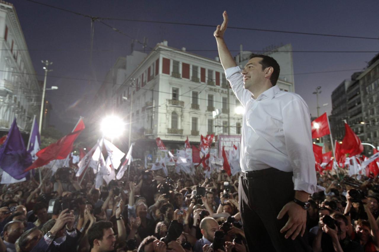 'Alexis Tsipras, the head of Greece\'s leftist SYRIZA party, waves at supporters during a pre-election rally in Athens June 14, 2012. Tsipras promised on Thursday to rip up the conditions attached to 