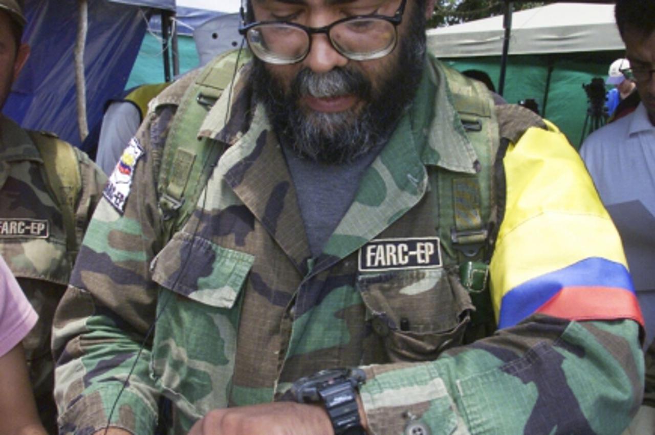 \'Colombian rebel Alfonso Cano, chief ideologist of the Revolutionary Armed Forces of Colombia (FARC), looks at his watch at a news conference near San Vicente del Caguan in this February 2, 2001 file
