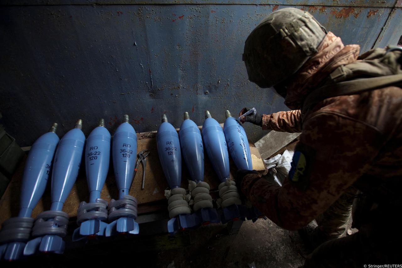 Ukrainian serviceman writes an inscription reading "Happy New Year" on a mortar shell before firing towards positions of Russian troops, in the outskirts of Bakhmut