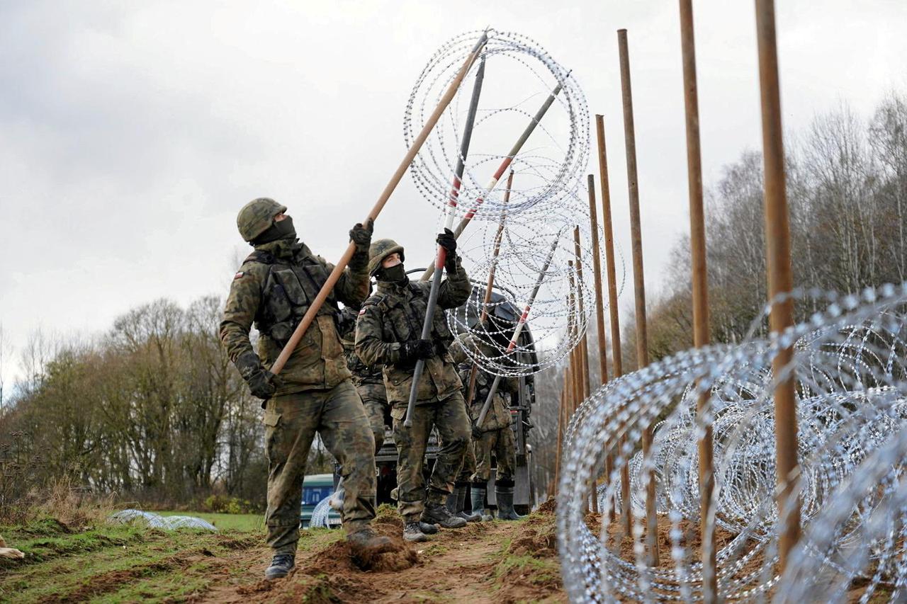 FILE PHOTO: Soldiers build razor wire fence on Poland's border with Russia's exclave of Kaliningrad near Bolcie