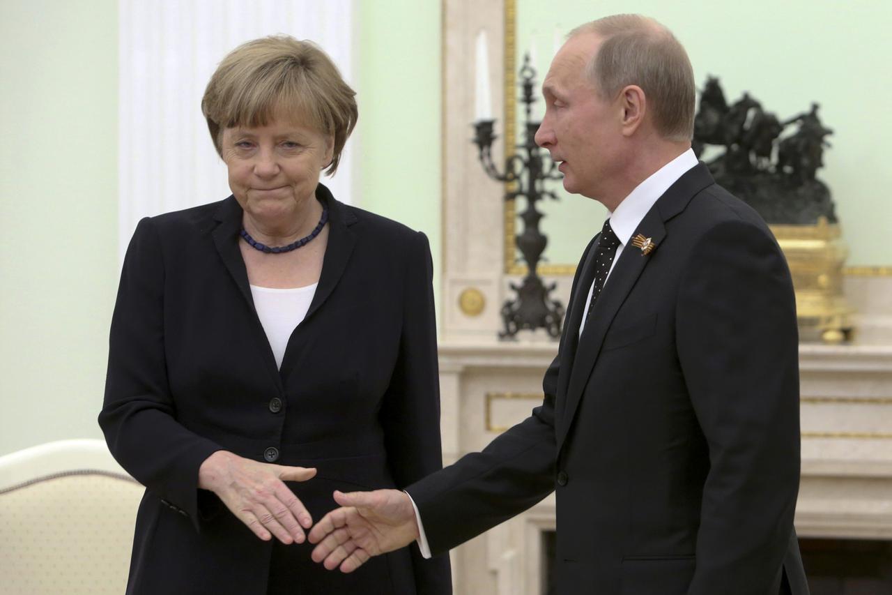 Russian President Vladimir Putin (R) approaches to shake hands with German Chancellor Angela Merkel during a meeting at the Kremlin in Moscow, Russia, May 10, 2015. Putin and Merkel will discuss the crisis in Ukraine at talks in Moscow on Sunday, a Kremli