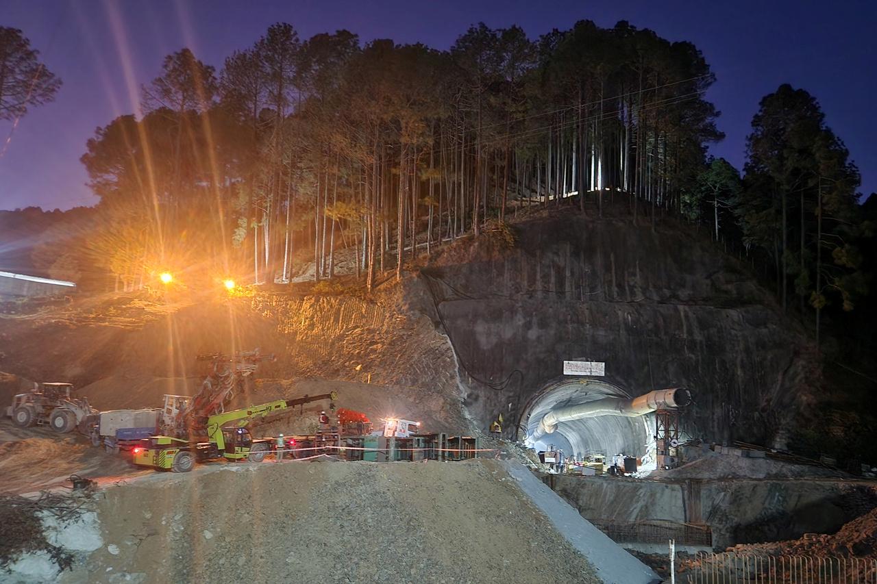 Rescuers move machines past a tunnel where workers are trapped, in Uttarkashi