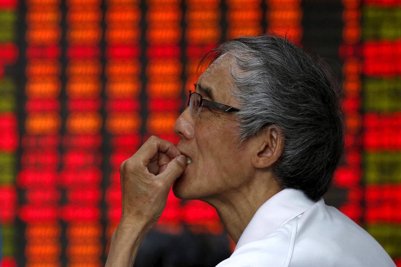 An investor looks at an electronic board showing stock information at a brokerage house in Shanghai, China, July 10, 2015. Chinese stocks rose strongly for a second day on Friday, buoyed by a barrage of government support measures, but worries persist abo