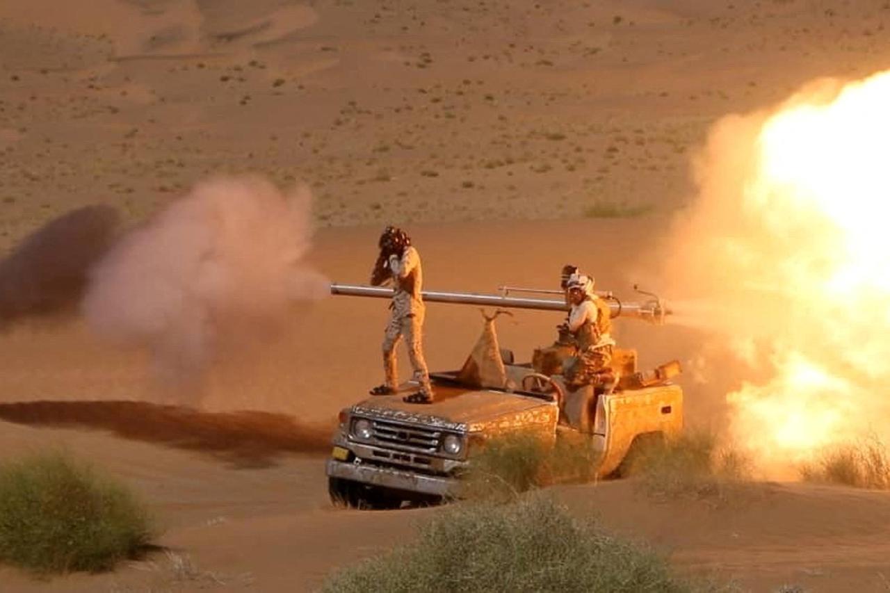 Yemeni government army soldiers fire a canon mounted on a vehicle at the frontline of fighting against Houthis in Marib