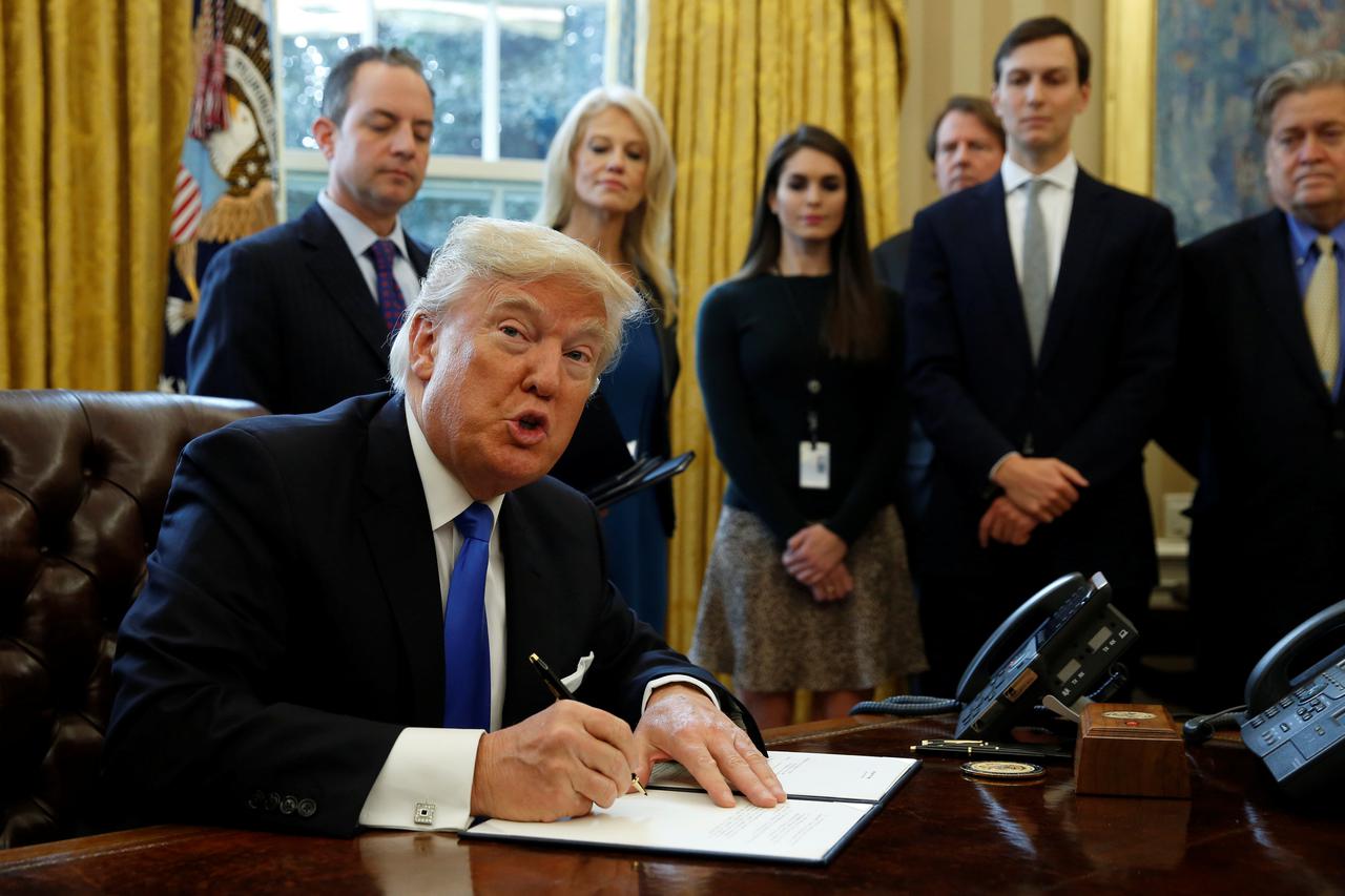 U.S. President Donald Trump looks up while signing an executive order to advance construction of the Keystone XL pipeline at the White House in Washington January 24, 2017.  REUTERS/Kevin Lamarque      TPX IMAGES OF THE DAY