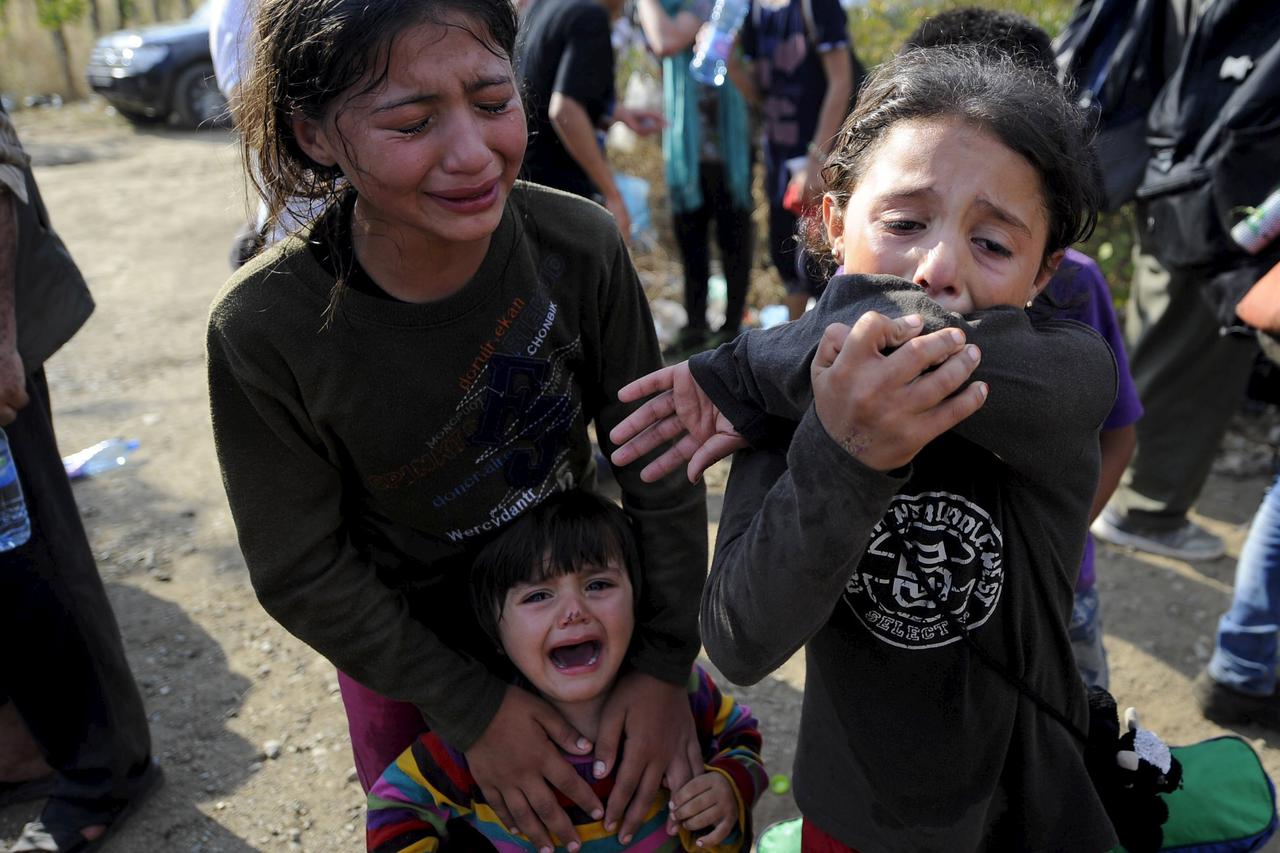 Girls cry as they get separated from their family at the border line dividing Macedonia and Greece August 21, 2015. At least 1,000 migrants and refugees pressed against Macedonian police lines on the Greek-Macedonian border on Friday and at least 10 peopl
