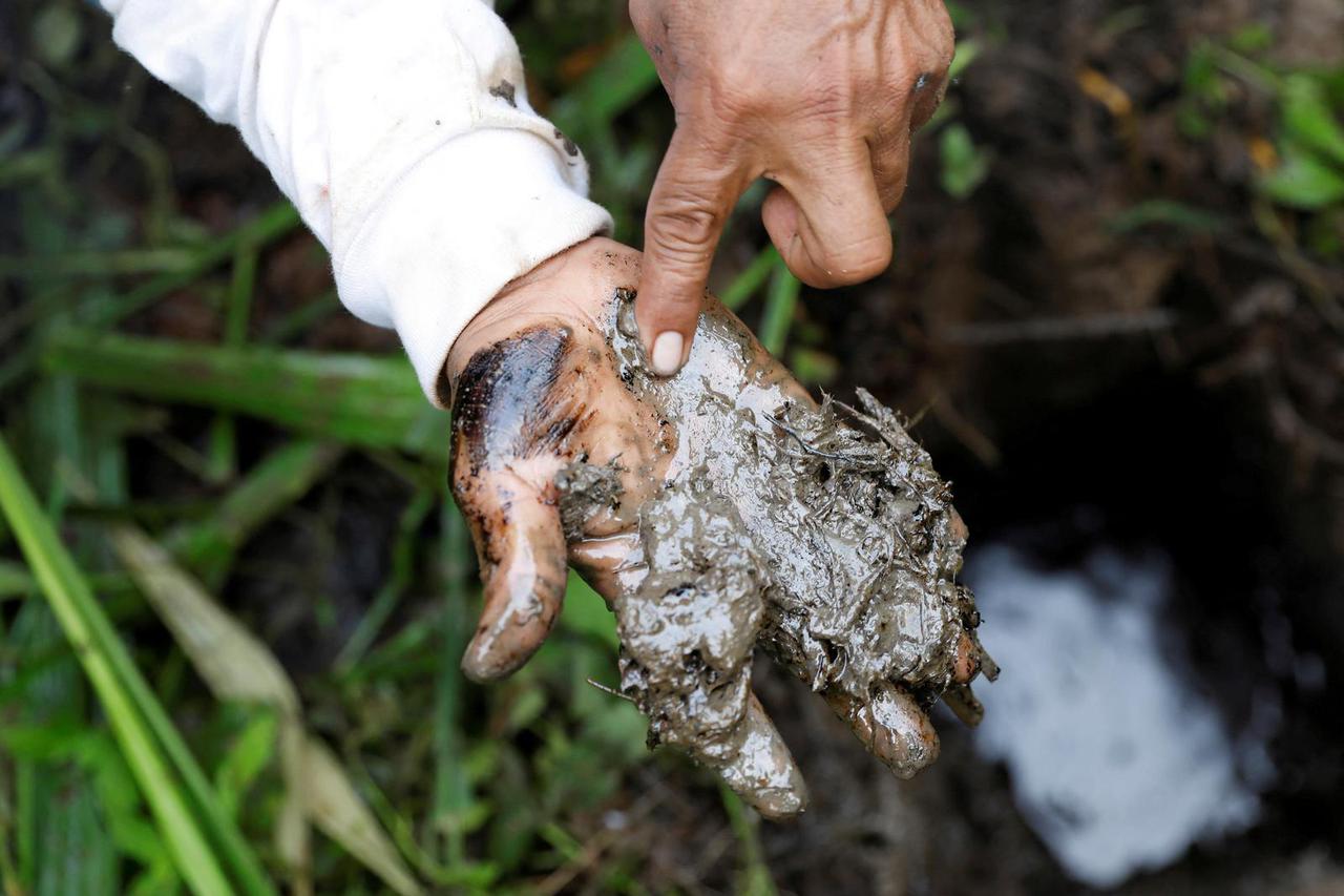 FILE PHOTO: A man shows oil contamination inside Block 192, a dormant Amazon oil field with a history of environmental spills