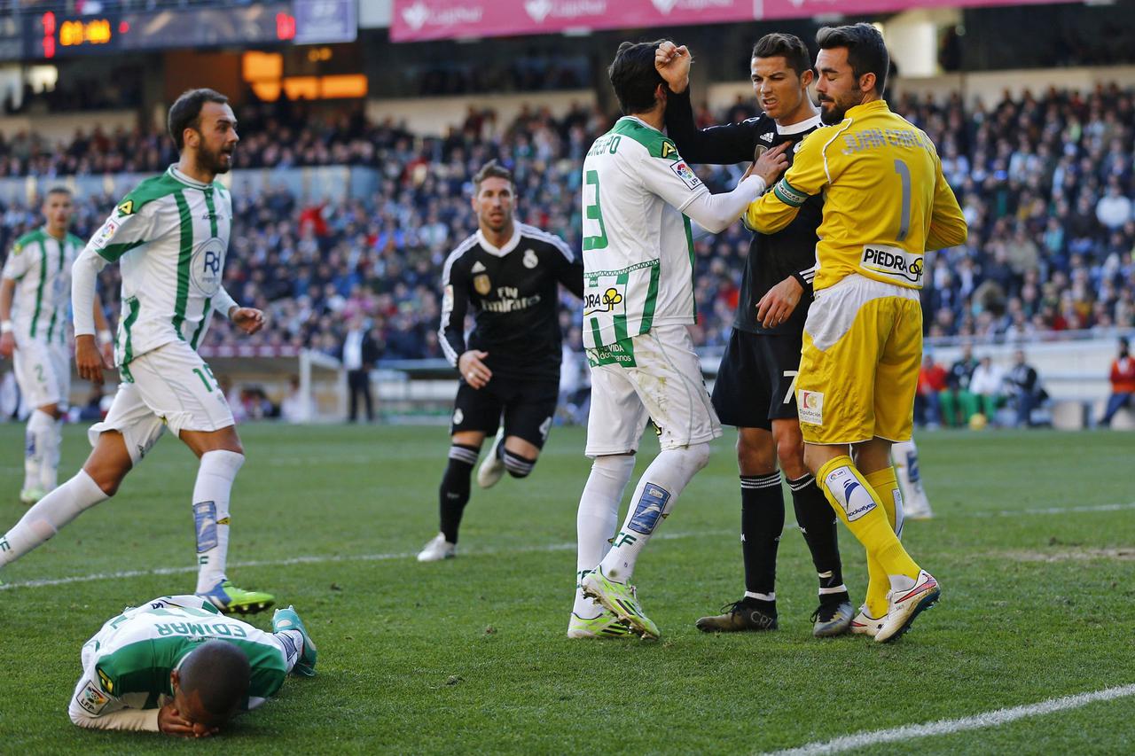 Real Madrid's Cristiano Ronaldo (2nd R) reacts as Cordoba's Edimar Fraga (bottom) lies on the pitch during their Spanish First Division soccer match at El Arcangel stadium in Cordoba, January 24, 2015. REUTERS/Marcelo del Pozo (SPAIN - Tags: SPORT SOCCER 