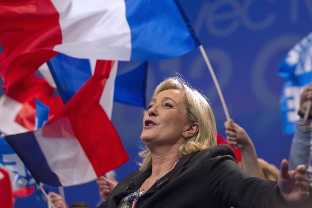 'President of French far-right party Front national (FN) and candidate for the 2012 French presidential election Marine Le Pen stands on stage with supporters holding French national flags during a sp