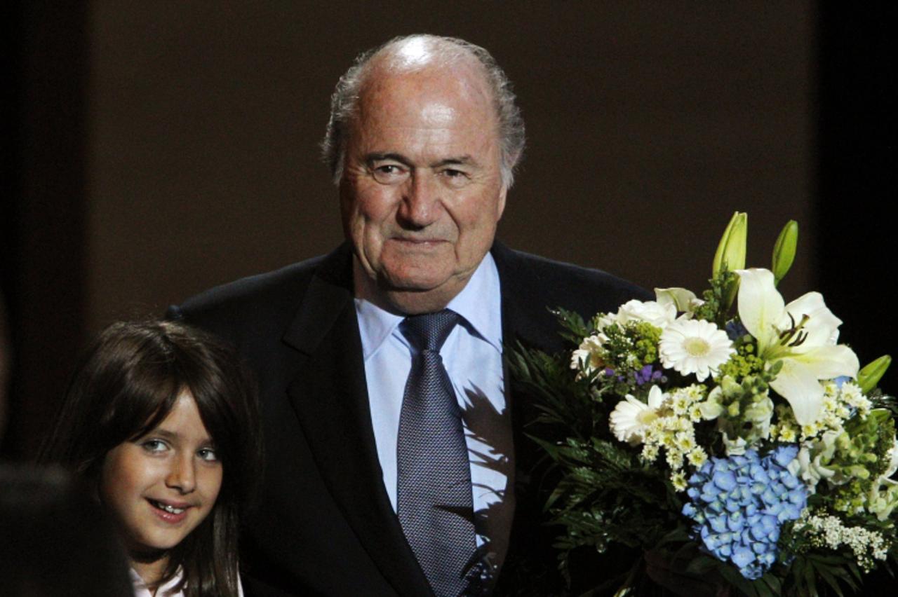 \'FIFA president Sepp Blatter holds flowers as he poses beside an unidentified girl after being re-elected for a fourth term as president of the world soccer governing body during the 61st FIFA congre