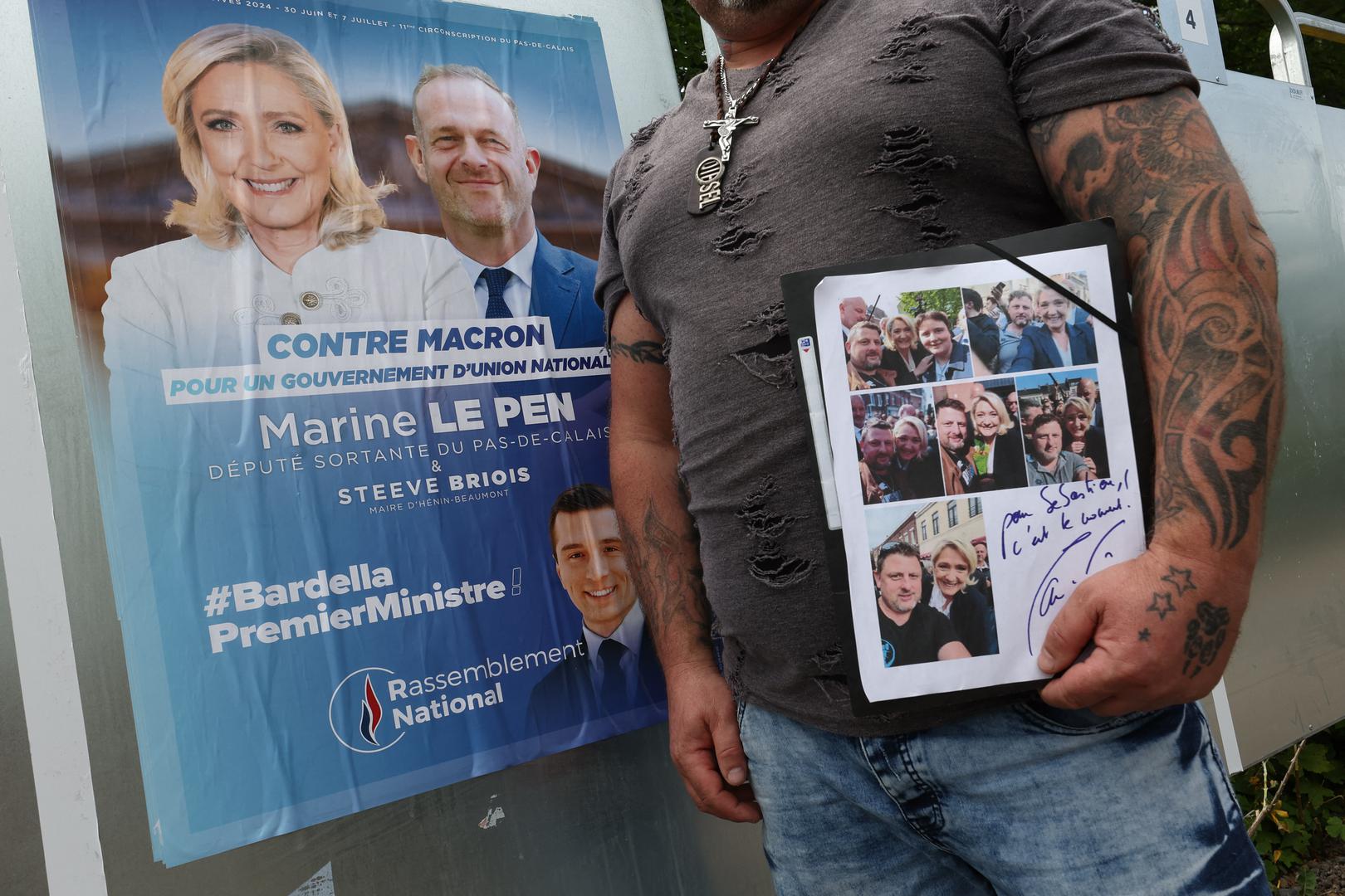Sebastien Ricart, 43, a supporter of Marine Le Pen, French far-right leader and far-right Rassemblement National (National Rally - RN) party candidate, stands by election boards, during the the first round of the early French parliamentary elections, in Henin-Beaumont, France, June 30, 2024. REUTERS/Yves Herman Photo: YVES HERMAN/REUTERS