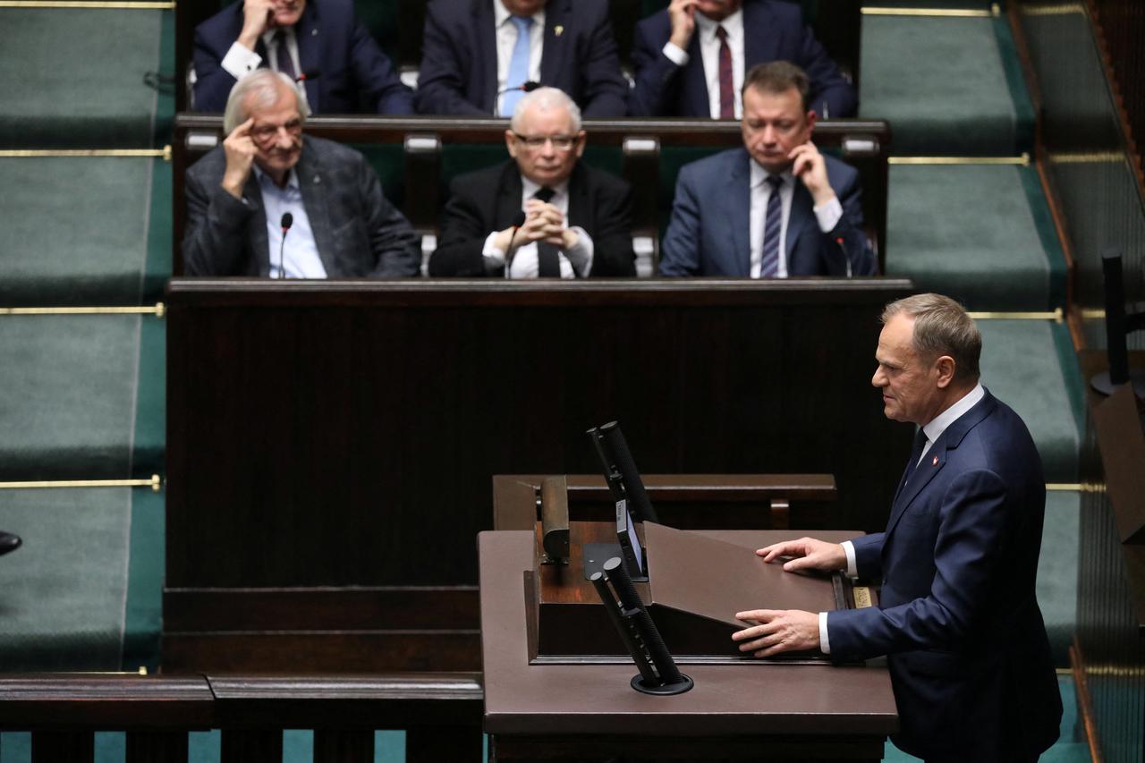 Leader of Law and Justice (PiS) Jaroslaw Kaczynski looks on as the leader of the Civic Coalition (KO) Donald Tusk speaks after the Parliament voted in favor of him becoming the Prime Minister