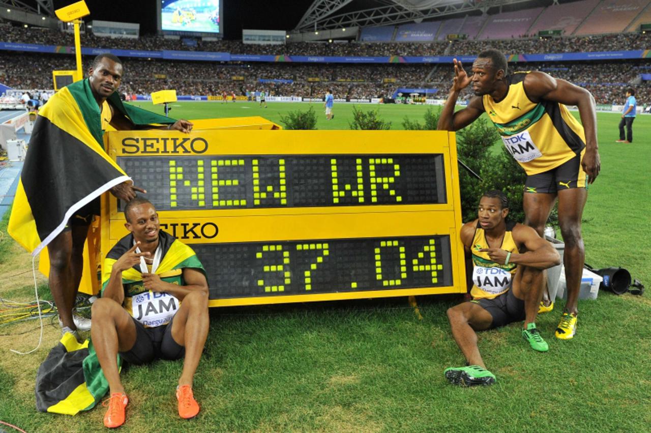 '(L-R) Jamaica\'s Nesta Carter, Michael Frater, Yohan Blake and Usain Bolt pose by the stop clock with their new world record time of 37.04 after winning the men\'s 4x100 metres relay final at the Int