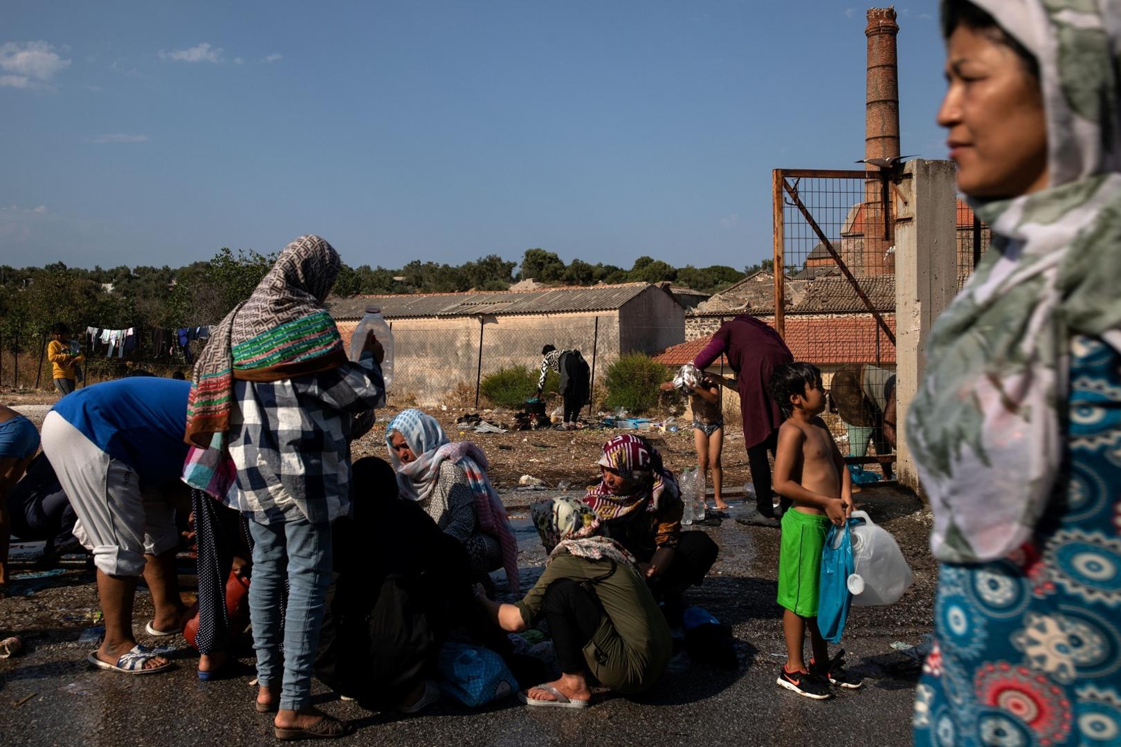 Refugees and migrants from the destroyed Moria camp wash and fill bottles with water, on the island of Lesbos Refugees and migrants from the destroyed Moria camp wash and fill bottles with water, on the island of Lesbos, Greece, September 12, 2020. REUTERS/Alkis Konstantinidis ALKIS KONSTANTINIDIS