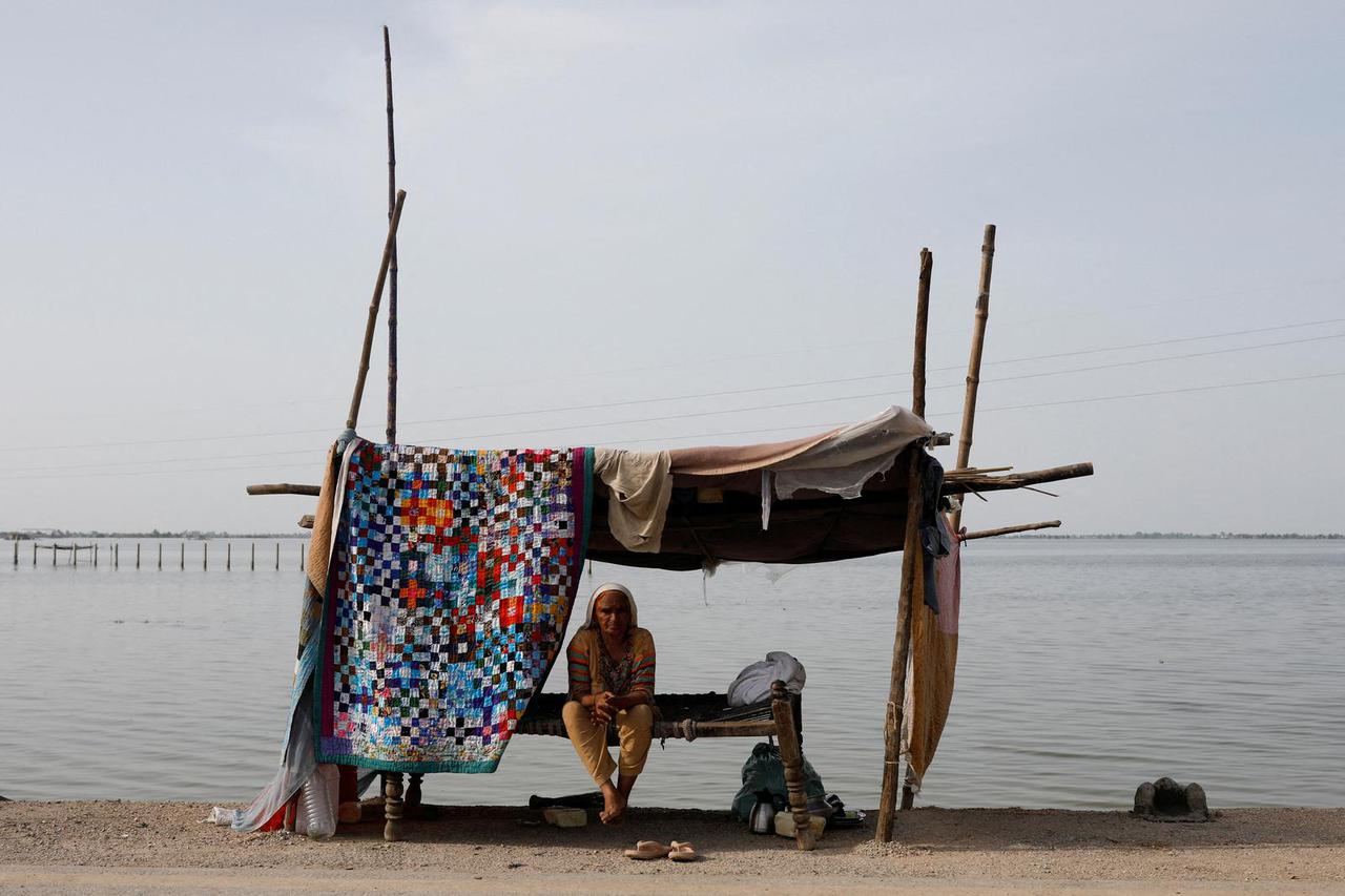 A flood victim takes refuge along a road in a makeshift tent, in Mehar