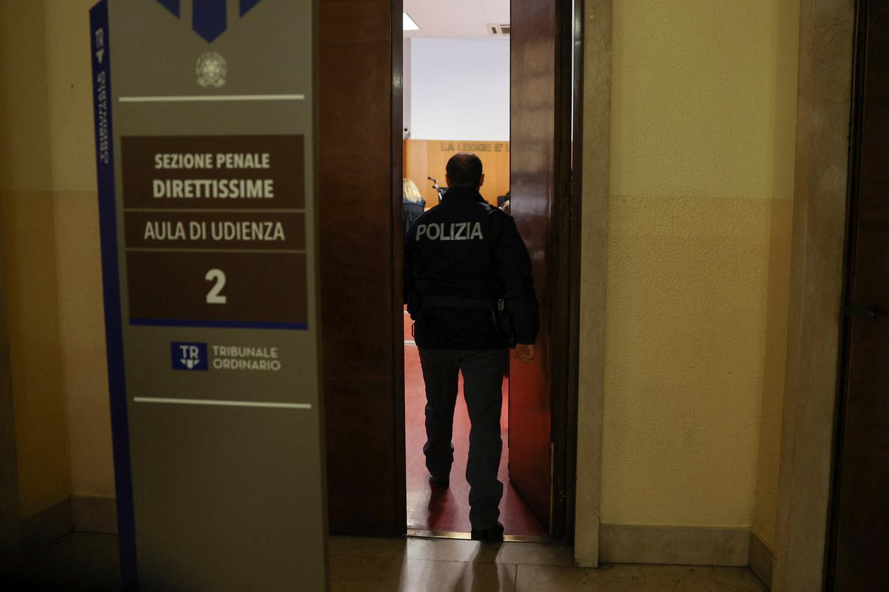 Police officer enters a courtroom at Milan Court of Justice