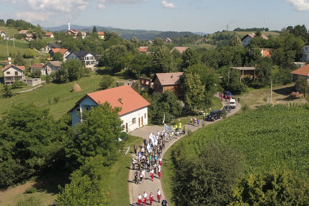 People walk through a forest near the village of Snagovo