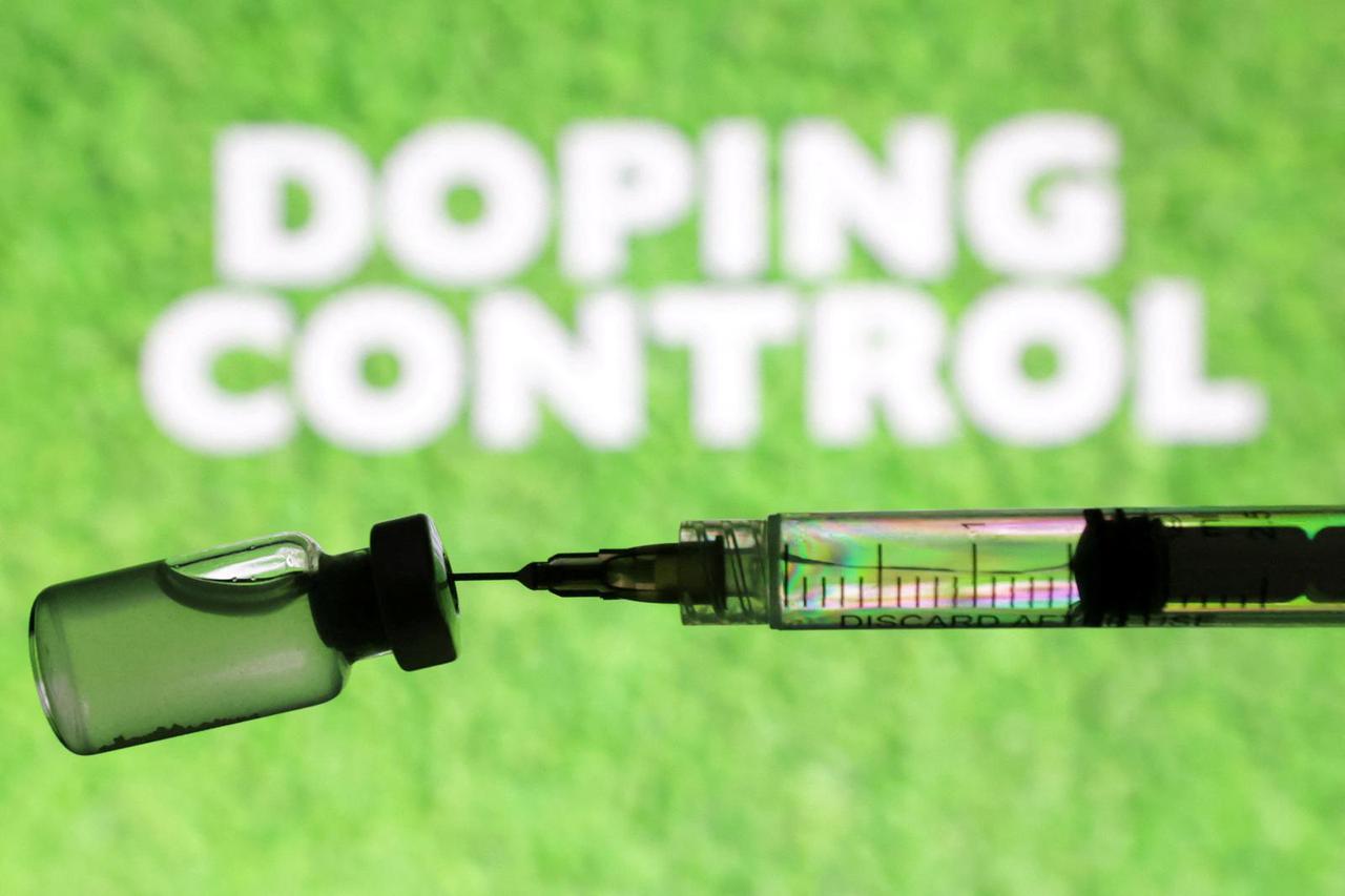 Illustration shows soccer terrain vial and syringe and words "Doping Control\