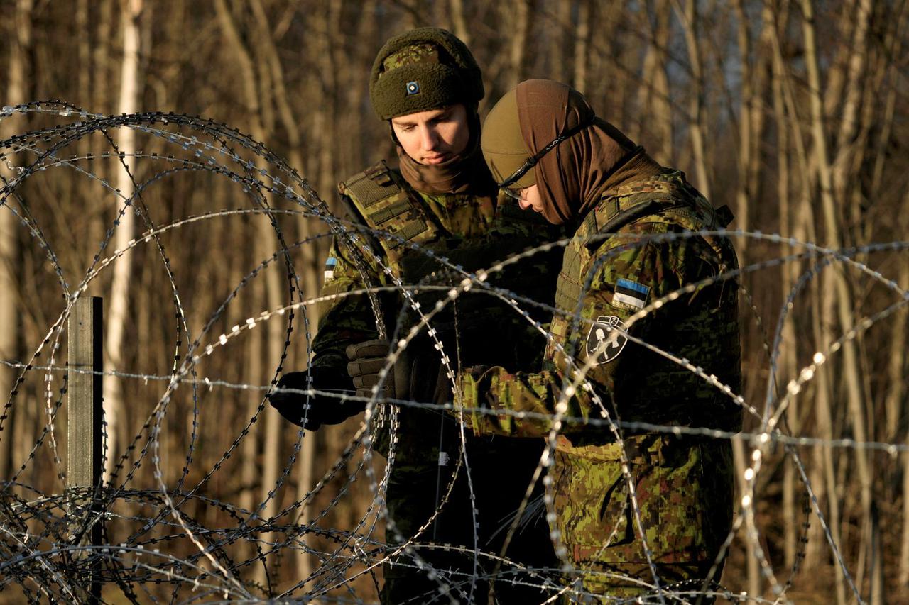 FILE PHOTO: Estonian army reservists build a fence on a border with Russia near Meremae