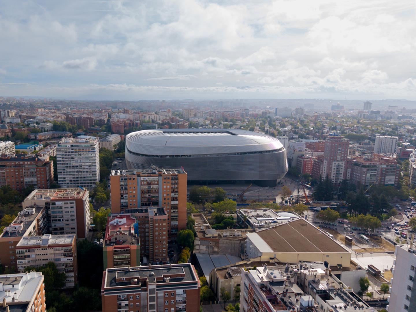 Još južnije, kultni dom proslavljenog madridskog Reala nedavno je prošao kroz nevjerojatno spektakularnu transformaciju. Monumentalni Santiago Bernabeu sada je elegantno obavijen sjajnom čeličnom fasadom koja mu daje izvanredan izgled golemog svemirskog broda, a njegov inovativni novi pomični krov i napredni sustav za sigurno podzemno skladištenje osjetljivog travnjaka dokazuju da se bogata europska nogometna povijest i najmodernija tehnologija današnjice mogu zaista savršeno nadopunjavati u samom središtu španjolskog glavnog grada.