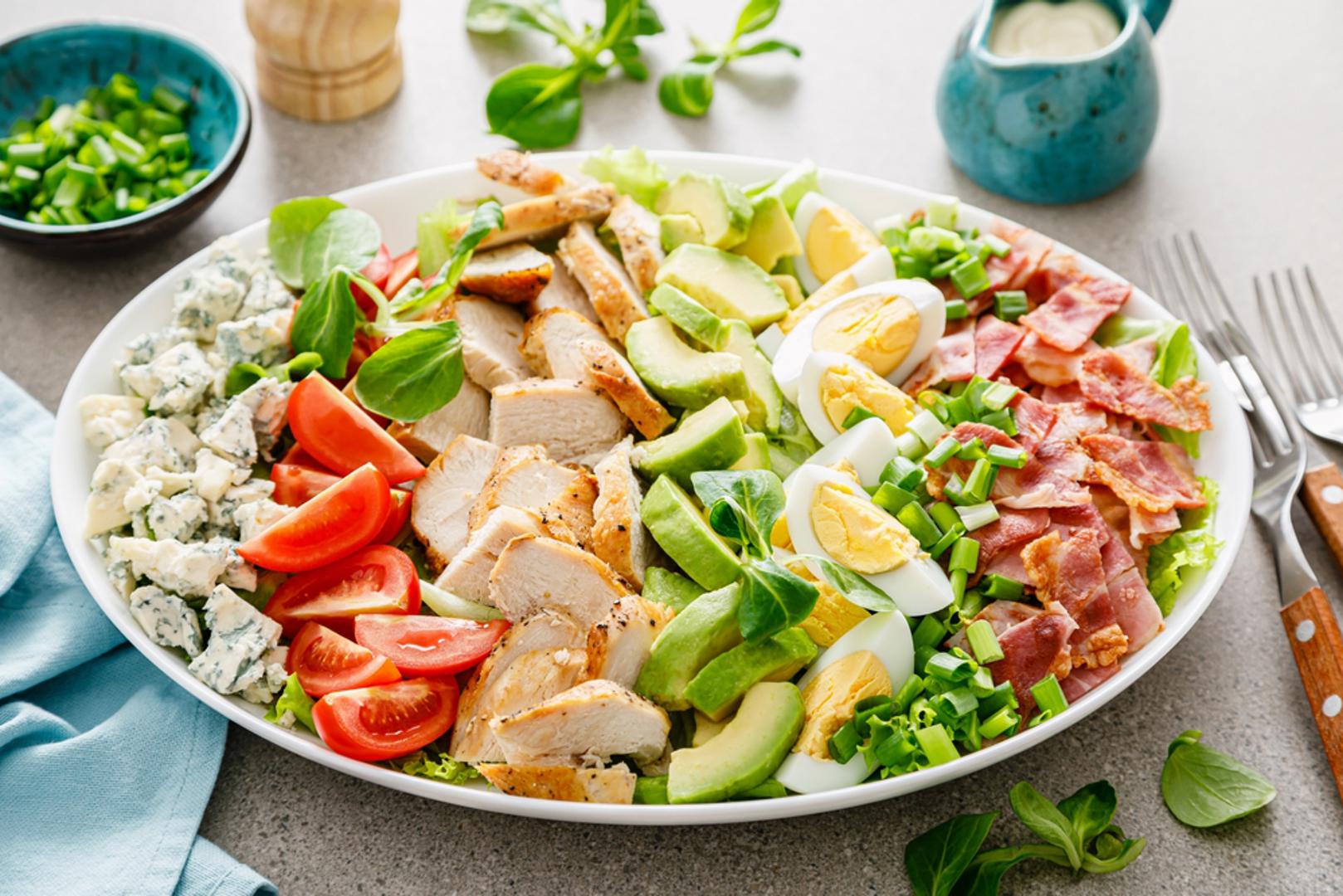 Cobb salata u lakšoj verziji: Cobb salata američki je klasik koji se najčešće priprema od zelene salate, piletine, jaja, rajčice, avokada i malo sira. Za zdraviju verziju ispecite ili skuhajte pileća prsa, narežite ih na trakice, dodajte kuhana jaja, cherry rajčice, krastavac, avokado i zelenu salatu, a umjesto teškog preljeva upotrijebite jogurt, limunov sok, malo maslinova ulja i senf. 