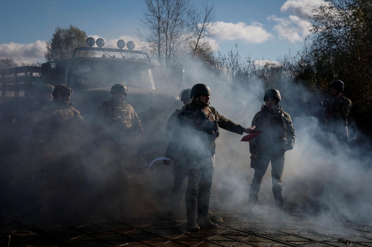 Ukrainian servicemen build pontoon bridges during an exercise in Chernihiv region