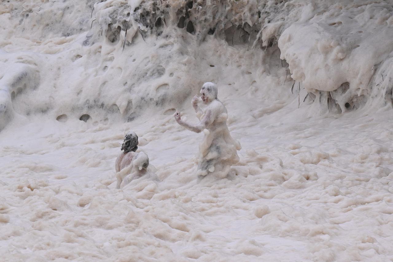Boys play in sea foam at Coolangatta ahead of Tropical Cyclone Alfred's landfall, on the Gold Coast