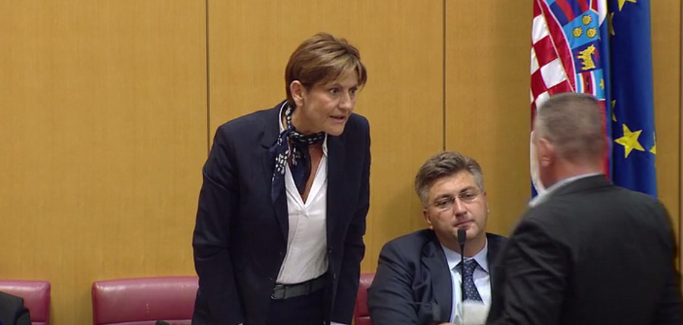 Bulj joj je prišao s fotografijama spornih spomenika koje je ona odgurnula i rekla: "Nemojte mi to davati".