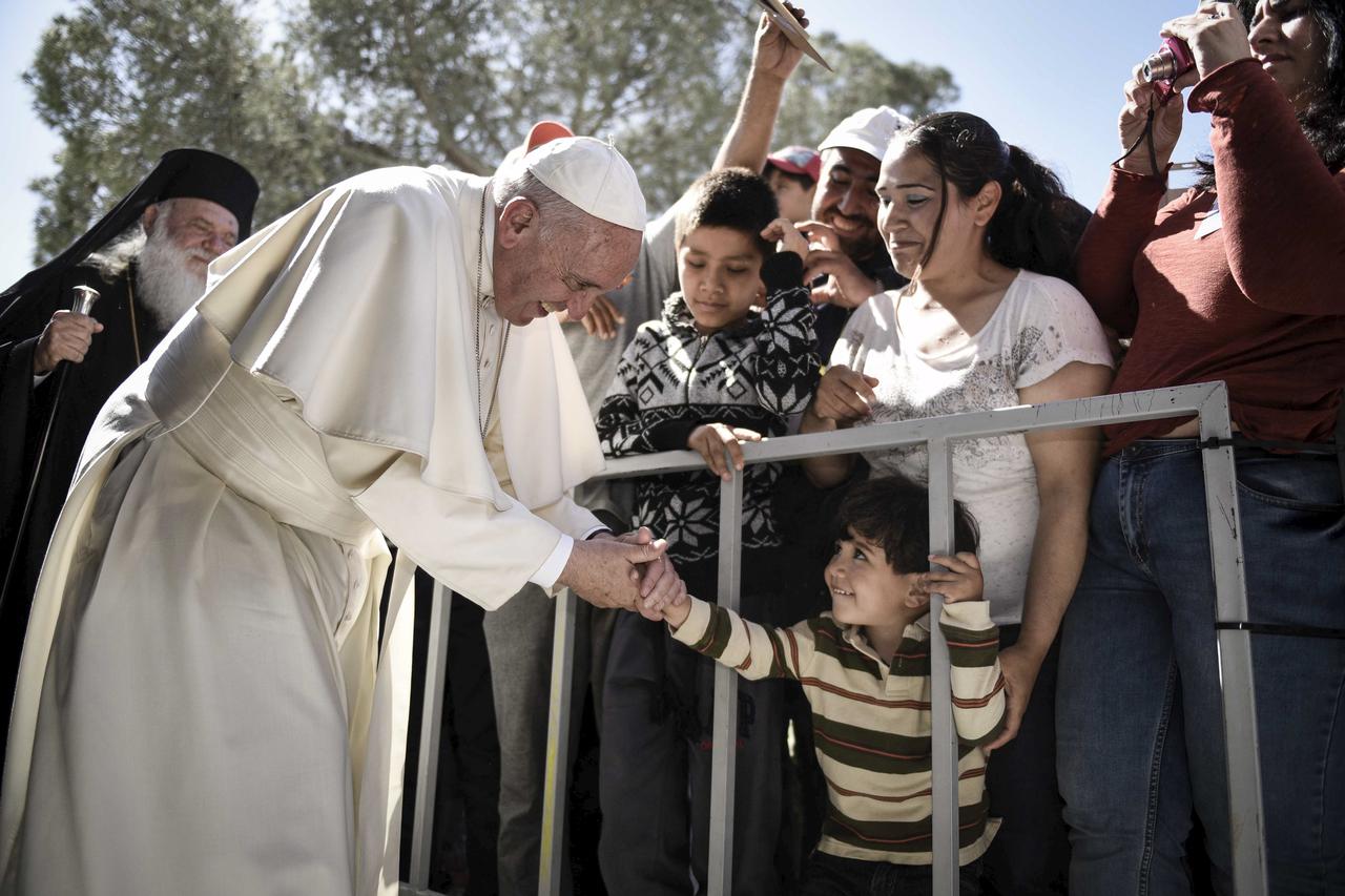 A boy shakes the hand of Pope Francis as he greets migrants and refugees at Moria refugee camp near the port of Mytilene, on the Greek island of Lesbos in this handout photo released by the Greek Prime Minister's press office, April 16, 2016. REUTERS/Andr
