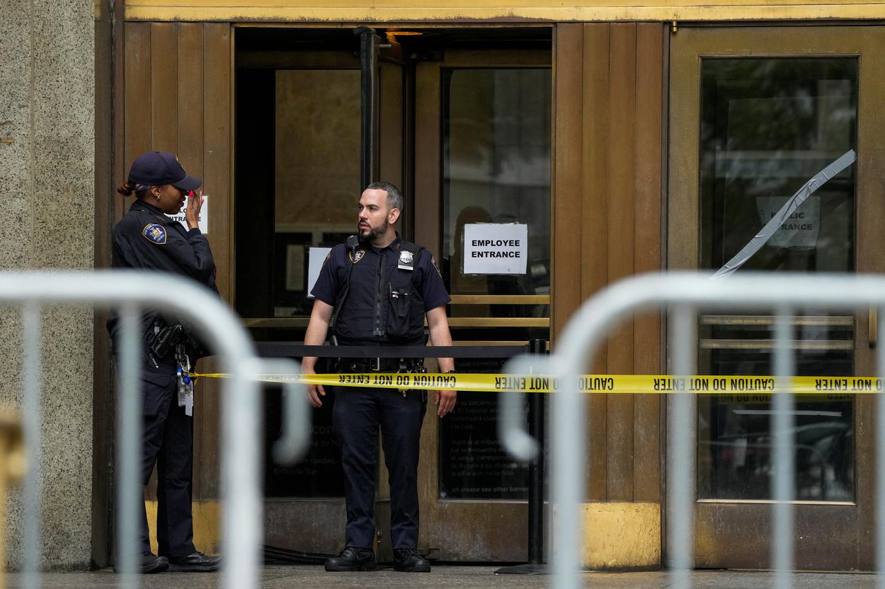 Police officers stand guard at the entrance of the Manhattan Criminal Court in New York